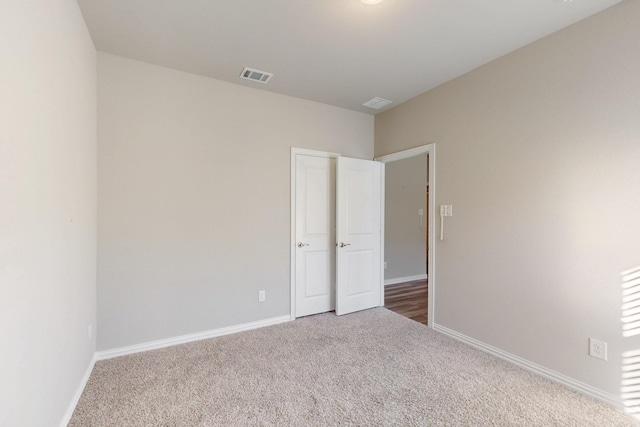 spare room with visible vents, baseboards, and carpet