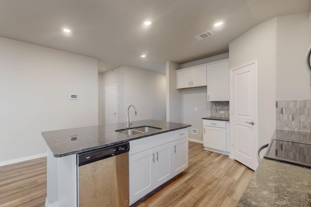 kitchen with visible vents, light wood finished floors, dark stone counters, a sink, and dishwasher