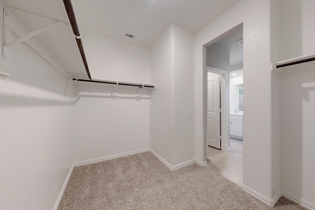 walk in closet featuring visible vents and light colored carpet