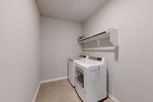 washroom featuring laundry area, separate washer and dryer, and baseboards