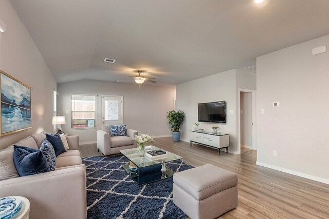 living room featuring visible vents, baseboards, light wood-style floors, and a ceiling fan