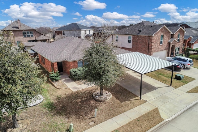 exterior space featuring brick siding, a residential view, and driveway