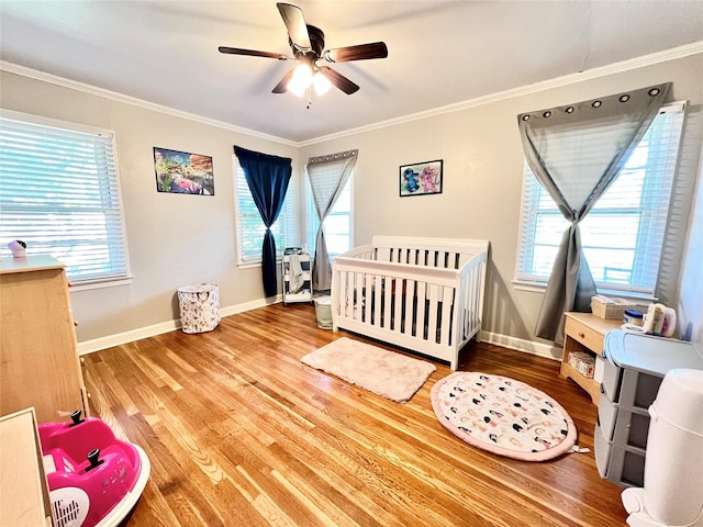 bedroom featuring multiple windows, wood finished floors, and ornamental molding