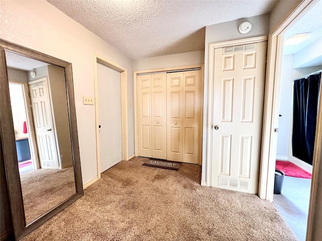 hallway featuring carpet and a textured ceiling