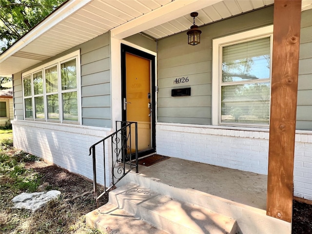 doorway to property featuring brick siding