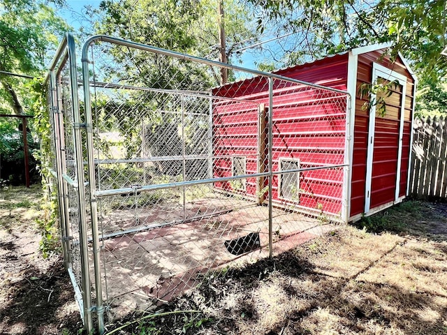 view of outdoor structure with fence, an outdoor structure, and a gate