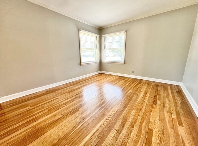 unfurnished room with light wood-style flooring, crown molding, and baseboards