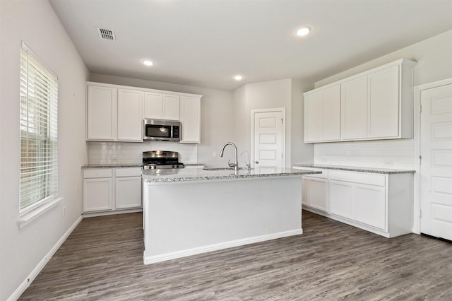 kitchen with a sink, white cabinetry, stainless steel appliances, and dark wood-style flooring