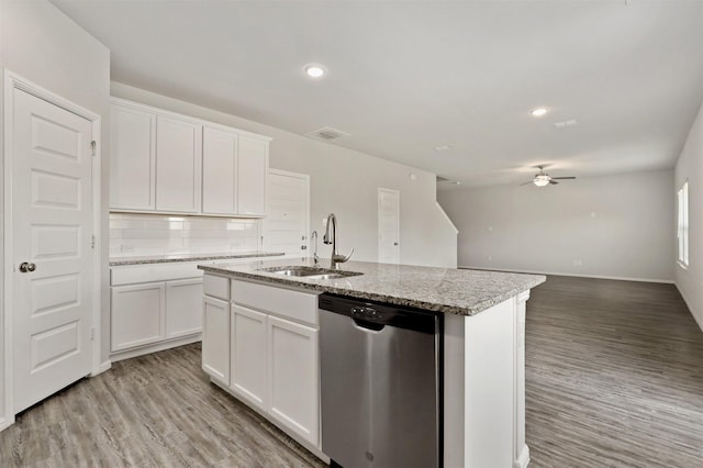 kitchen featuring a sink, decorative backsplash, stainless steel dishwasher, and light wood finished floors