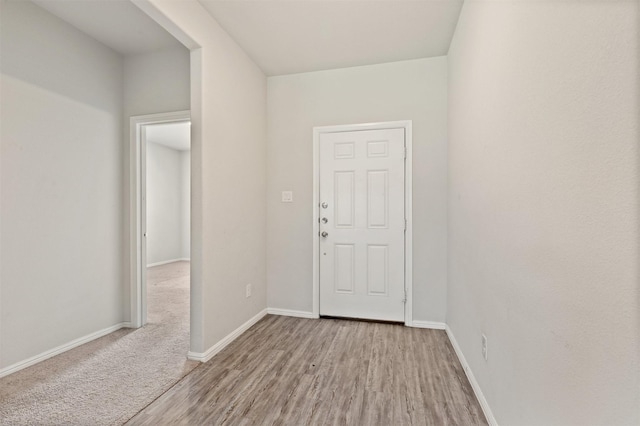 foyer entrance with wood finished floors and baseboards