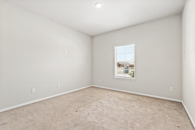 carpeted empty room featuring baseboards