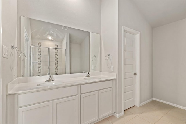 full bathroom featuring tile patterned flooring, double vanity, a stall shower, and a sink