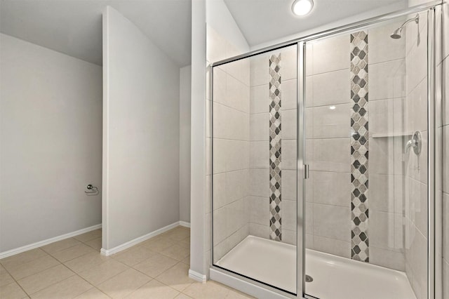 bathroom featuring baseboards, a stall shower, and tile patterned flooring