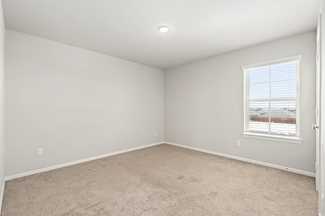 spare room with carpet and baseboards