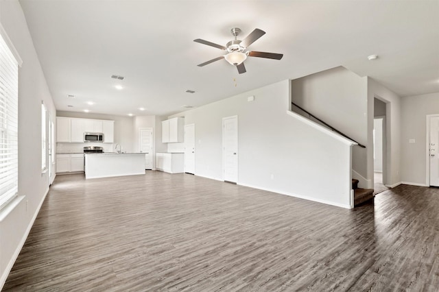 unfurnished living room featuring baseboards, stairs, recessed lighting, wood finished floors, and a ceiling fan