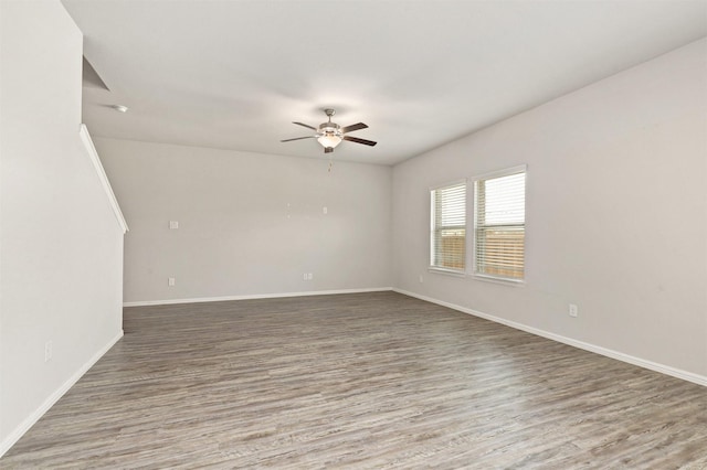 unfurnished room featuring wood finished floors, baseboards, and ceiling fan