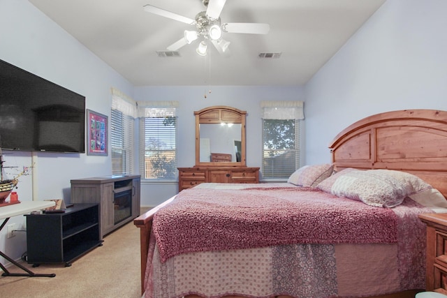 bedroom with light colored carpet, visible vents, and ceiling fan