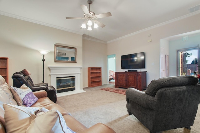 living area with visible vents, a glass covered fireplace, crown molding, light colored carpet, and ceiling fan