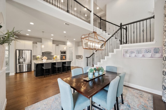 dining room featuring stairs, visible vents, dark wood-style flooring, and baseboards