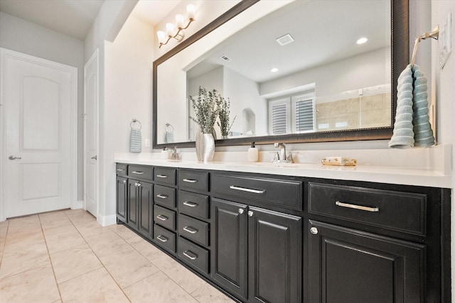 bathroom with double vanity, visible vents, and a sink