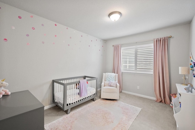 bedroom featuring baseboards, carpet floors, and a crib