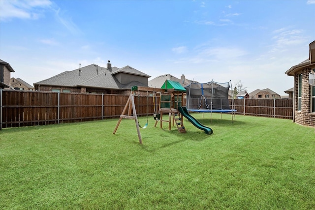 view of playground featuring a trampoline, a fenced backyard, and a yard