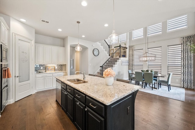 kitchen featuring visible vents, a sink, dishwasher, white cabinetry, and dark cabinets