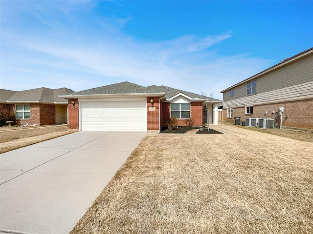 ranch-style house featuring brick siding, a shingled roof, central AC, a garage, and driveway