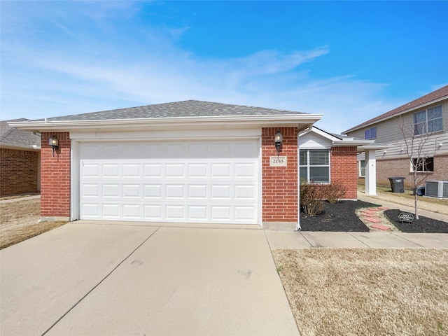 single story home with brick siding, central air condition unit, roof with shingles, a garage, and driveway