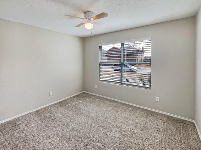 empty room with carpet, a ceiling fan, baseboards, and a textured ceiling