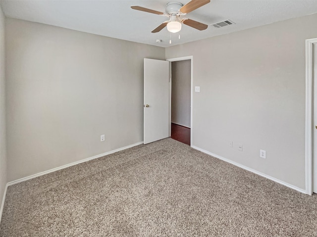 carpeted spare room with a ceiling fan, baseboards, and visible vents