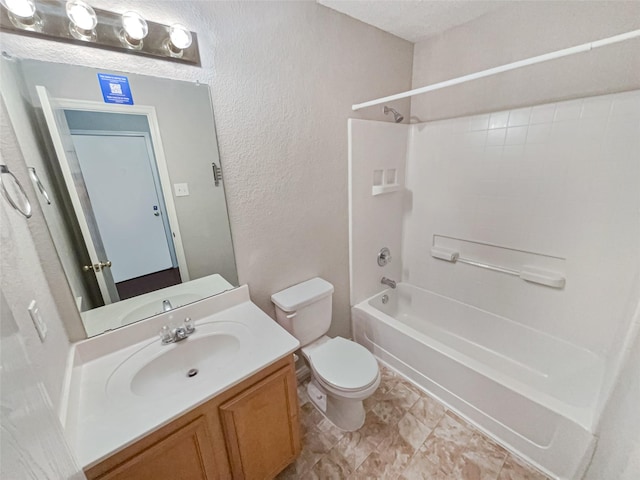 bathroom with vanity, toilet, tub / shower combination, and a textured wall