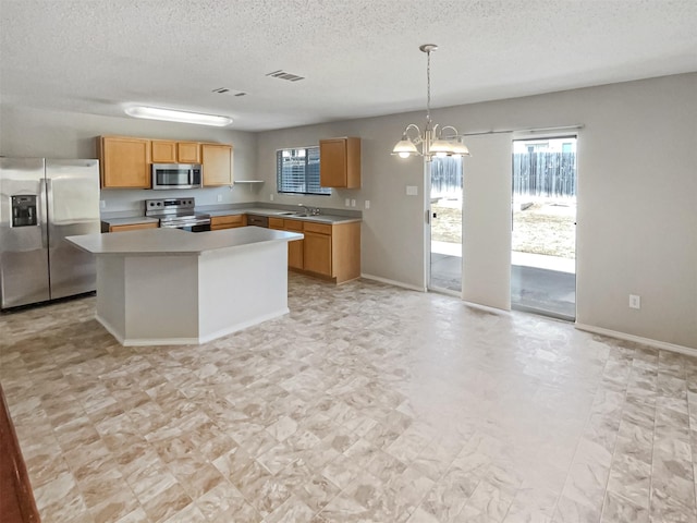 kitchen featuring visible vents, light countertops, appliances with stainless steel finishes, a notable chandelier, and a sink