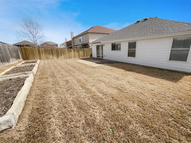 view of yard with a patio area, a vegetable garden, and a fenced backyard