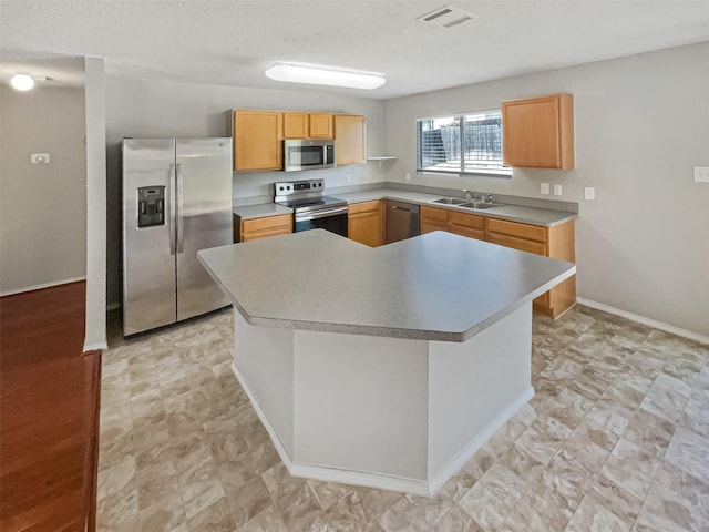 kitchen with visible vents, a sink, a kitchen island, stainless steel appliances, and baseboards