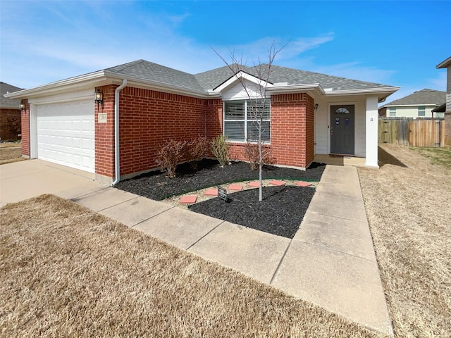 single story home featuring brick siding, an attached garage, a shingled roof, and fence