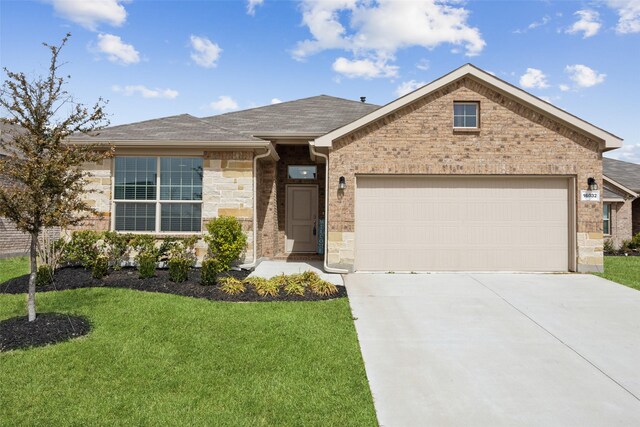 ranch-style home with roof with shingles, concrete driveway, a front yard, an attached garage, and brick siding