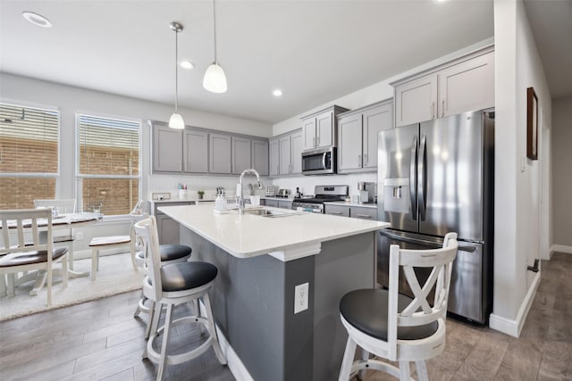 16032 Bronte Ln, Fort Worth, TX 76247 - kitchen featuring a sink, gray cabinetry, a breakfast bar area, and stainless steel appliances