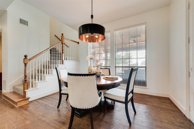 dining room featuring visible vents, stairway, baseboards, and wood finished floors