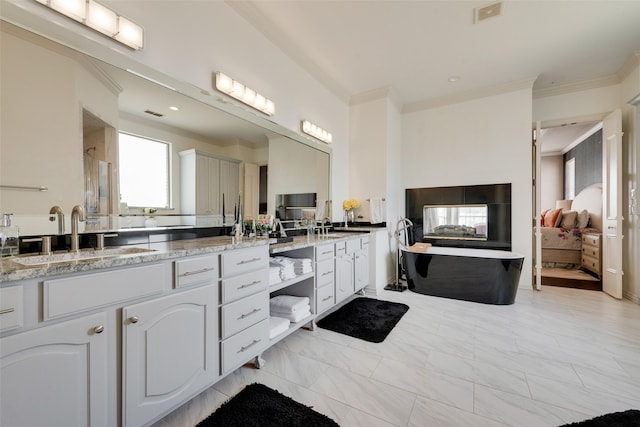 bathroom with visible vents, a stall shower, crown molding, a soaking tub, and vanity