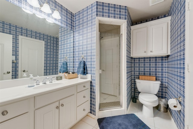 bathroom featuring vanity, tile patterned flooring, a shower stall, tile walls, and toilet