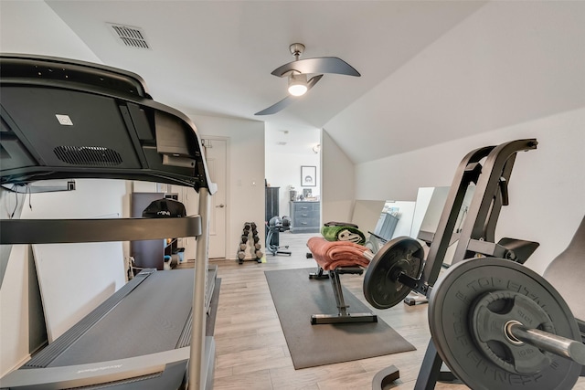 workout room with ceiling fan, visible vents, lofted ceiling, and wood finished floors