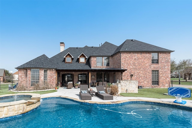 back of property with fence, brick siding, a shingled roof, and a patio area