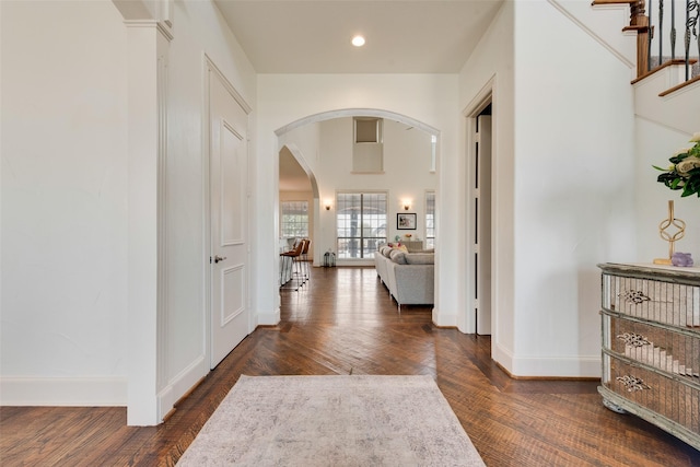 entryway with recessed lighting, baseboards, arched walkways, and dark wood-style floors