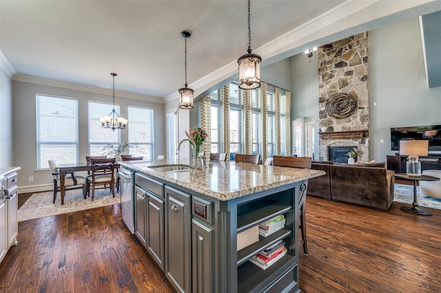 kitchen featuring a sink, a stone fireplace, dark wood-style flooring, and crown molding