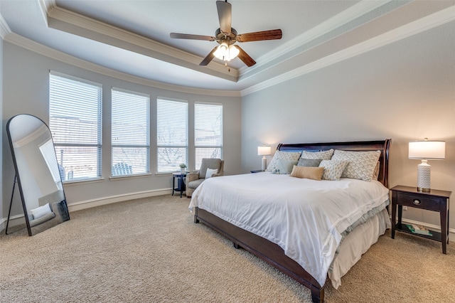 bedroom featuring ceiling fan, carpet flooring, baseboards, crown molding, and a tray ceiling