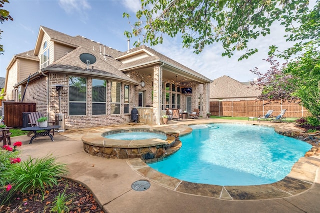 view of pool with a patio, outdoor dining space, a fenced backyard, and a pool with connected hot tub