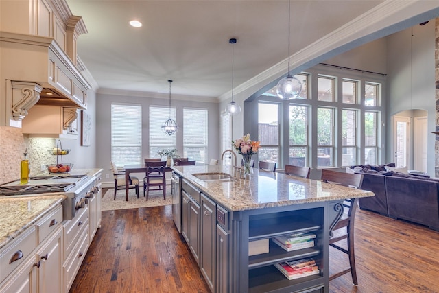 kitchen with a sink, a breakfast bar, stainless steel appliances, dark wood-style floors, and ornamental molding