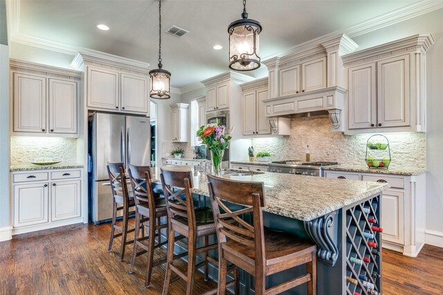 kitchen with dark wood-style flooring, freestanding refrigerator, ornamental molding, a kitchen breakfast bar, and decorative light fixtures