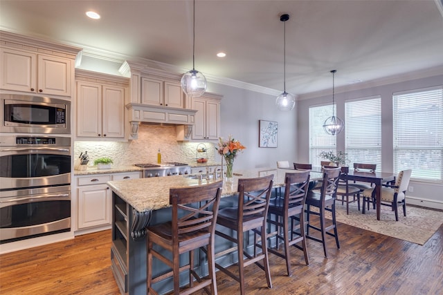 kitchen with light stone countertops, recessed lighting, decorative backsplash, stainless steel appliances, and crown molding